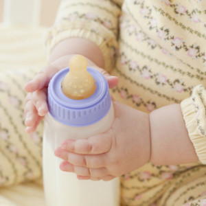 Bébé qui tient un biberon