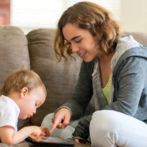 Jeune assistante maternelle qui s'amuse avec un bébé