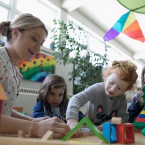 Animatrice de crèche entourée d'enfants