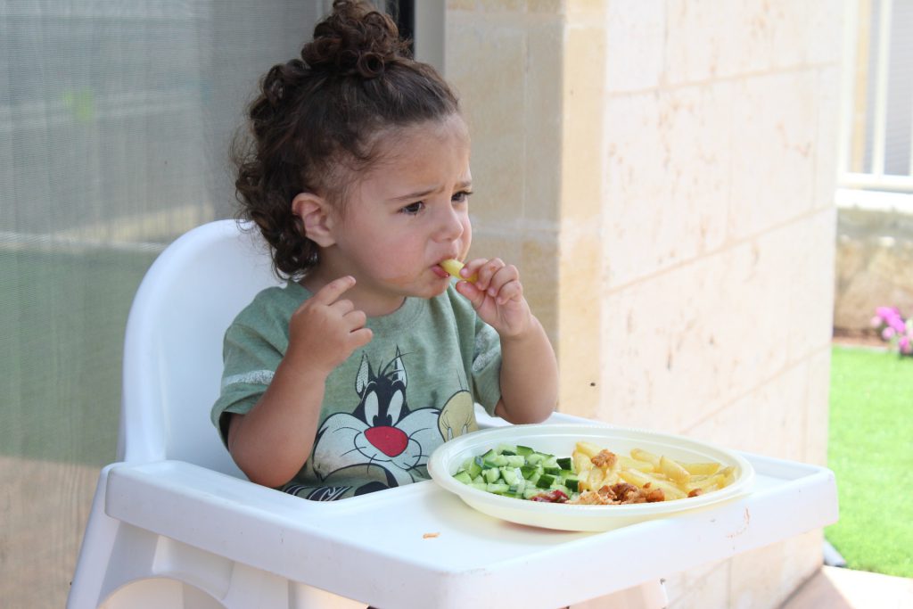 Bébé sur sa chaise haute en train de manger