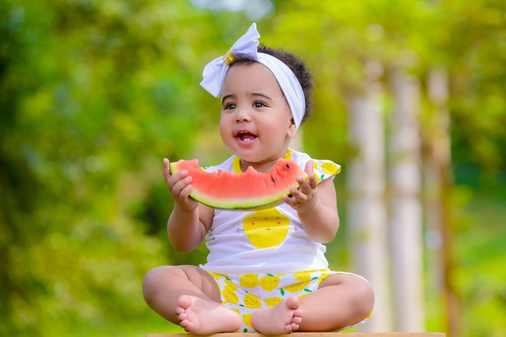 Petite fille tenant un morceau de pastèque